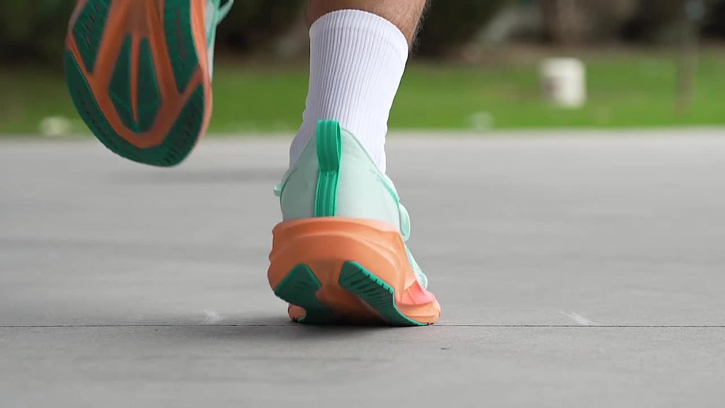 ASICS Novablast 5 Aqua / Orange – lifestyle en mouvement, vue arrière